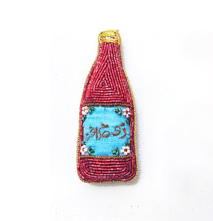 A set of handcrafted garland ornaments with symbols representing South Asian culture, including an orange mango, a blue and white rooh afza drink, a samosa, and a yellow and green jalebi.