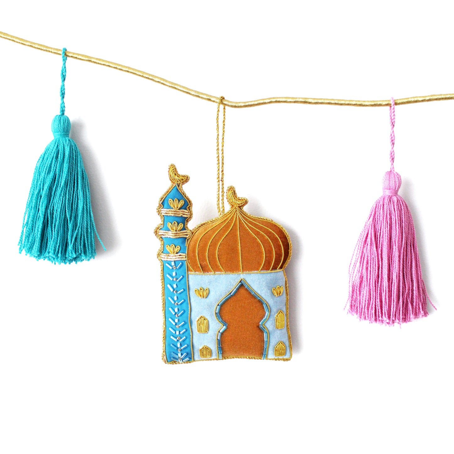 Decorative banner with a mosque-shaped ornament and tassels on a white background